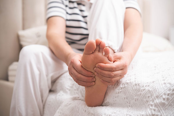 Eine Seniorin hält ihre Füße bei der medizinischen Fußpflege im Rahmen der Service-Angebote.